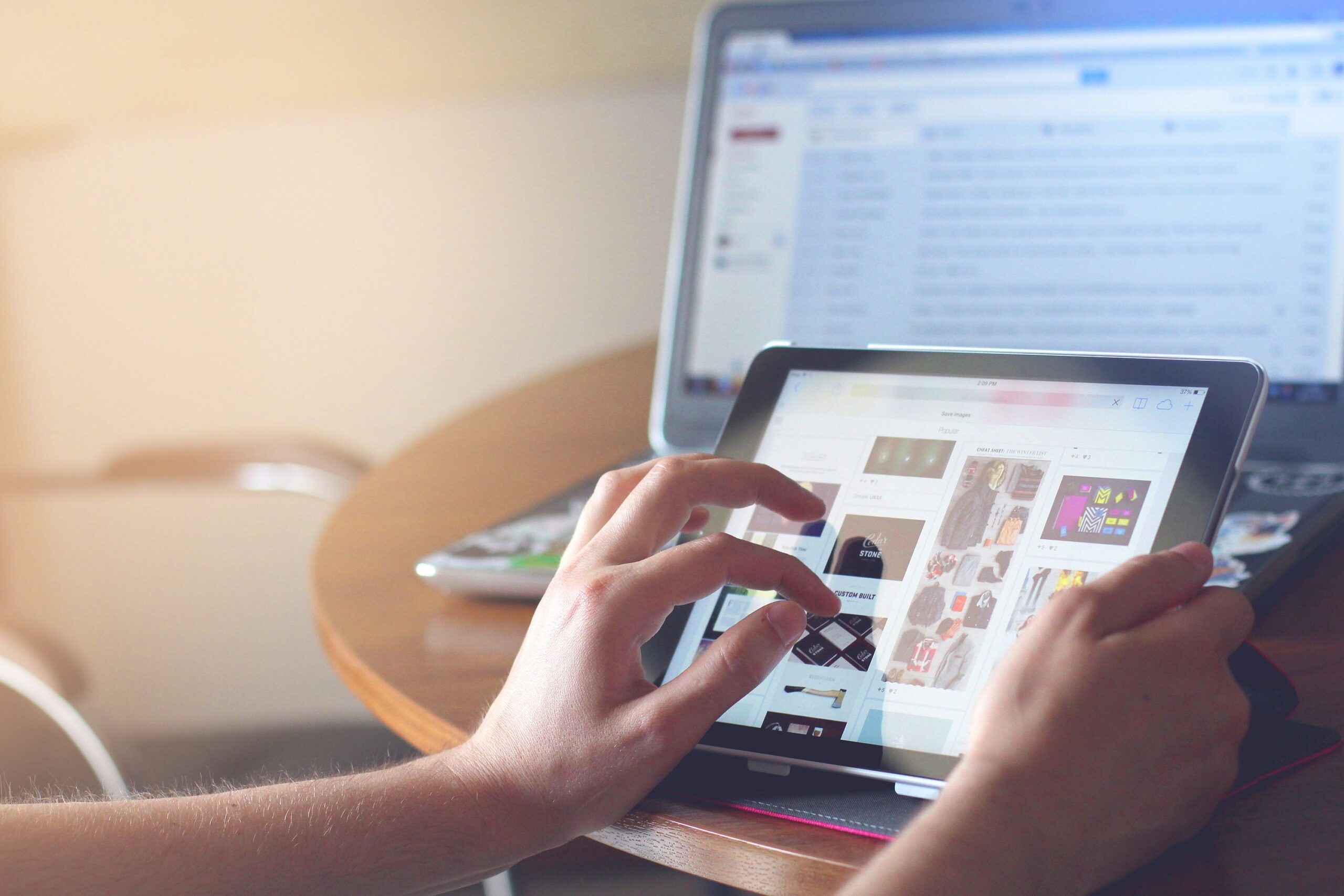 Business devices in use: a person working on a tablet with a laptop behind