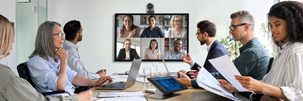 Q-SYS meeting room: a boardroom video call with remote participants on screen