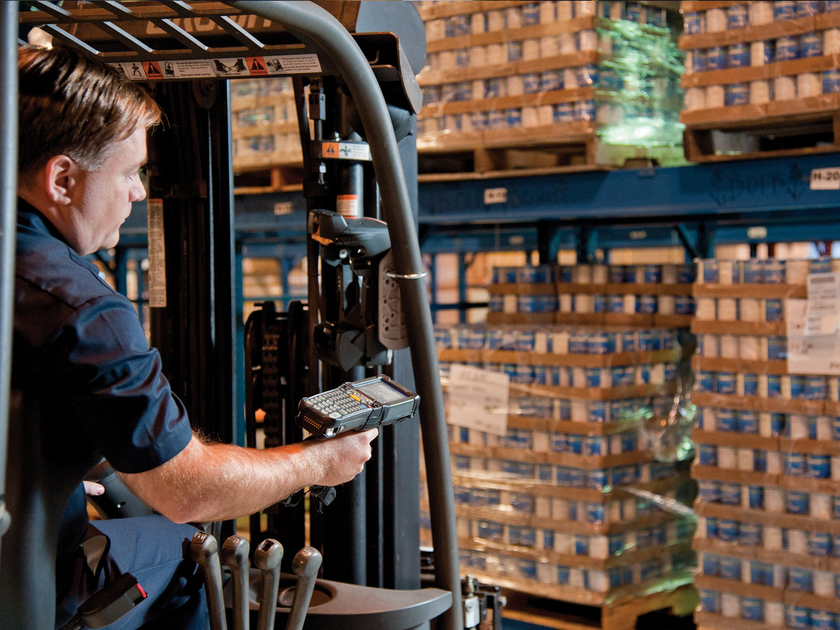 Forklift driver scanning pallets of stock with a rugged handheld mobile computer